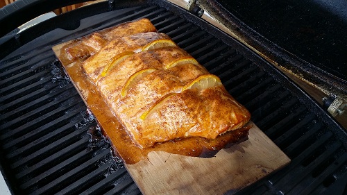 Lachsfilet mit Zitronen Scheiben auf Zedernholzbrett gegrillt